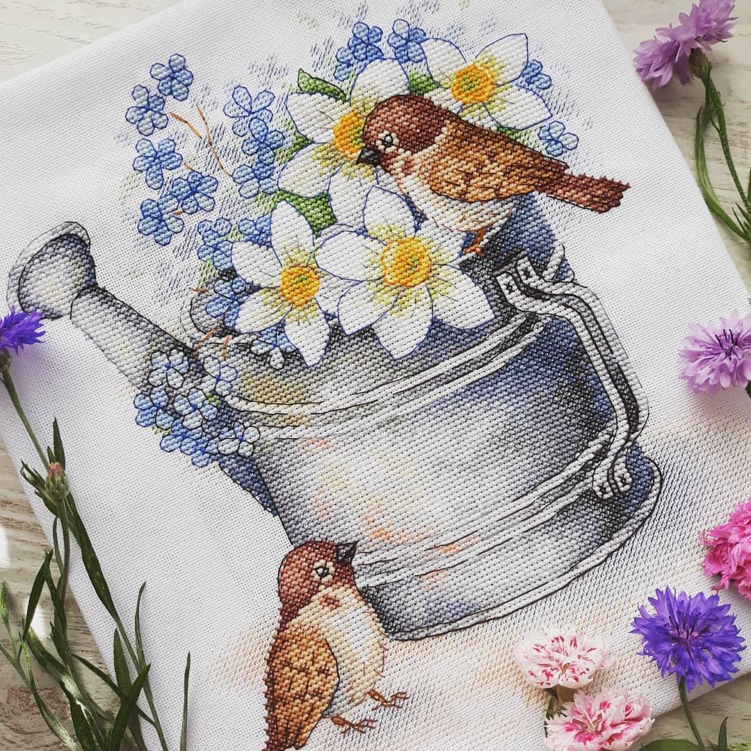 Daffodil Lovers SA-026 Cross-stitch kit featuring a watering can, white chamomiles, blue flowers, and a bullfinch on 27 count canvas.